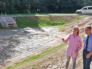 Birgit Imhof, für den Landkreis zuständige Abteilungsleiterin im Wasserwirtschaftsamt, und Thomas Hornung, Leiter des städtischen Tiefbauamtes, am Rand des 1850 Kubikmeter Wasser fassenden Mischwasser-Rückhaltebeckens; links die Überlauf-Vorrichtung.  Fotos: Sigismund von Dobschütz