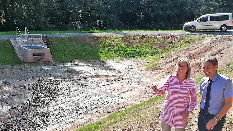 Birgit Imhof, für den Landkreis zuständige Abteilungsleiterin im Wasserwirtschaftsamt, und Thomas Hornung, Leiter des städtischen Tiefbauamtes, am Rand des 1850 Kubikmeter Wasser fassenden Mischwasser-Rückhaltebeckens; links die Überlauf-Vorrichtung.  Fotos: Sigismund von Dobschütz
