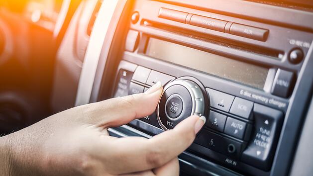 Frau bedient Radio im Auto