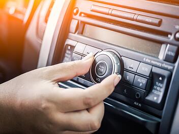 Frau bedient Radio im Auto