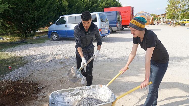 Johannes Kobras aus der F.E.E.L-Effect-Gruppe (rechts) zusammen mit einem Geflüchteten bei der Installation eines Basketballkorbes im Rahmen des Projekts "Habibi.Works" in Nordgriechenland. Foto: F.E.E.L-Effect