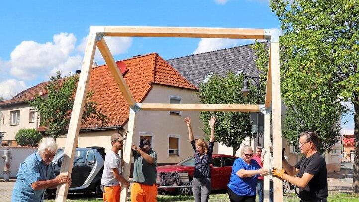 Viele Hände machen schnell ein Ende: beim Aufbau des Klimawürfels in Adelsdorf packten Mitgliedern des Bunds Naturschutz, der Pressesprecher des Vereins "Energiewende ER(H)langen", Rudi Ackermann, Bauhofmitarbeiter und Bürgermeister Karsten Fischkal mit an. Foto: Johanna Blum