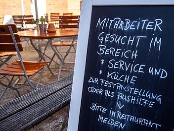 Auf einer Tafel vor einem Restaurant wird nach Mitarbeitern für den Service- und Küchenbereich gesucht.  Foto: Jens Büttner/dpa