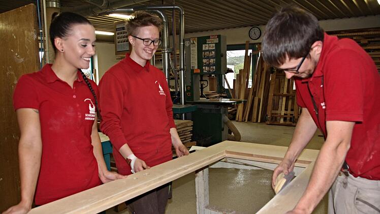 Der "Ausländer" aus der Oberpfalz, Schreinermeister Lucas Zimmer, bei einer Oberflächenbehandlung, wobei ihm Selina Lassmann und Svenja Hastedt (von links) auf die Finger schauen. Foto: Helmut Will