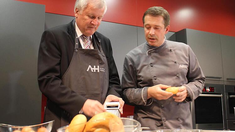 Zu Beginn fühlte sich Horst Seehofer in seiner Schürze etwas unwohl. Er holte sich bei Sternekoch Alexander Herrmann wertvolle Tipps. Fotos: Martin Kreklau