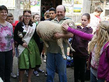 Sogar die Bayerische Wollkönigin Kerstin Müller kam zum Kindertag auf den Hof Wächter in Wülflingen. Unser Bild zeigt von links Irmhild Hill-Wächter, Wollkönigin Kerstin Müller und Schafhalter Gerhard Wächter sowie einige Schüler der 5b der Mittelschule Haßfurt. Foto: Sabine Weinbeer