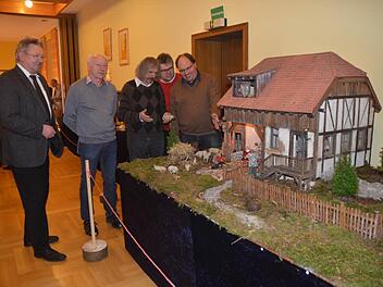 Über eine gelungene und sehenswerte Krippenausstellung im Pfarrheim in Pressig freuten sich (v. l.) Bürgermeister Hans Pietz, Heinrich Grebner, Pater Helmut Haagen und Klaus Herbst - hier an der Darstellung von Michael Suffa (r.), der hier sein Werk erläutert. Foto: Karl- Heinz. Hofmann