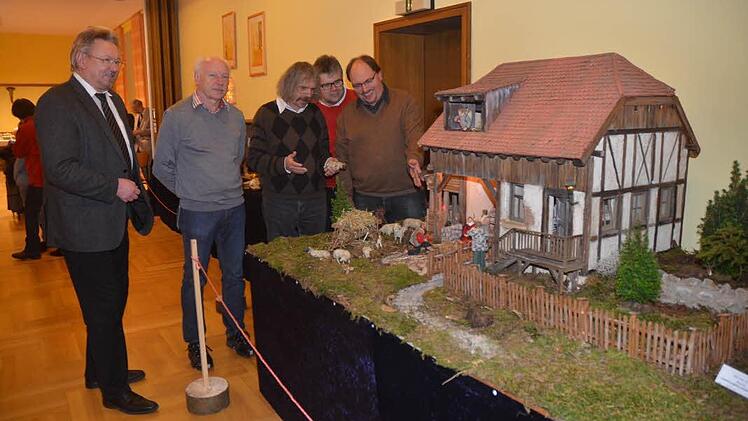 Über eine gelungene und sehenswerte Krippenausstellung im Pfarrheim in Pressig freuten sich (v. l.) Bürgermeister Hans Pietz, Heinrich Grebner, Pater Helmut Haagen und Klaus Herbst - hier an der Darstellung von Michael Suffa (r.), der hier sein Werk erläutert. Foto: Karl- Heinz. Hofmann