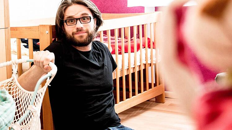 Florian Herrnleben sitzt geschafft vor dem Kinderbett. Antonia als Vertreterin der fünften Generation der Puppenbühne Herrnleben schlummert währenddessen friedlich.  Foto: Pia Nagel