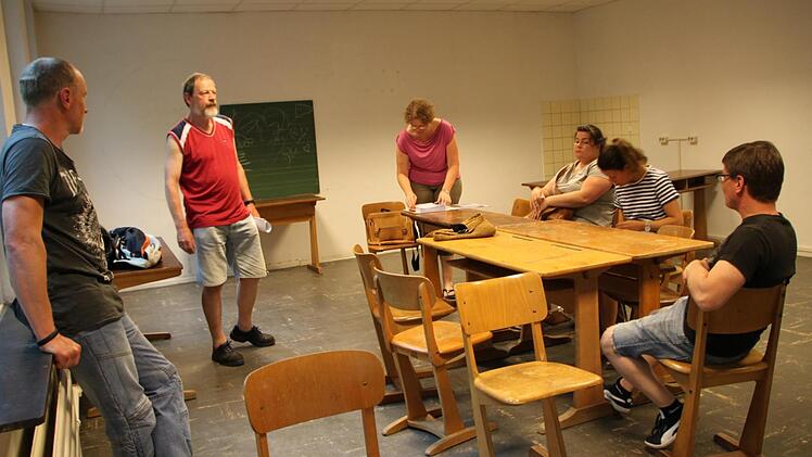 Abgewetzter Fußboden, Holzmöbel und eine Tafel: Am Raum, in dem die Stadt in Zukunft einen Anlaufpunkt für Jugendliche anbieten will, ist noch so gut wie nichts gemacht worden. Hier treffen sich die Verantwortlichen von InJusa (Integragtionsbezogene Jugendsozialarbeit). Foto: Ulrike Müller