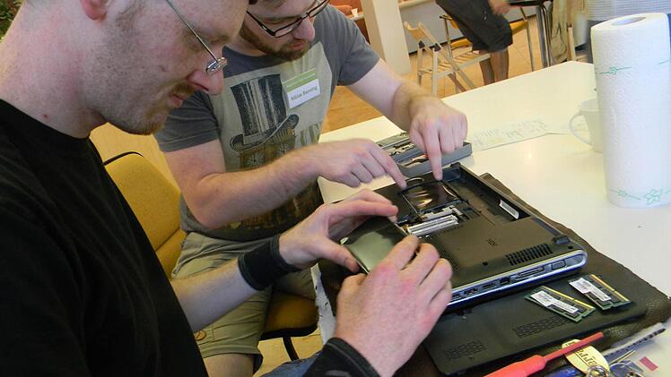 Niklas Banning (r ) erklärt Robert Jones wie er das Innere seines Laptops reinigen muss.  Foto: Lengenfelder