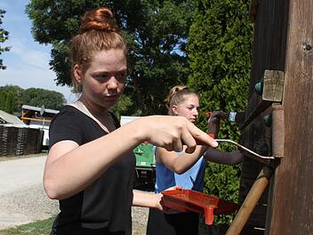 Damit die Schüler kostenlos auf dem Campingplatz schlafen dürfen, packen sie beim Renovieren des Spielplatzes mit an. Aliyah und Johanna streichen hier gerade das Spielgerät. Fotos: Sarah Stieranka