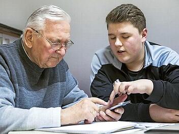 Diethmar Jahn (links) h&ouml;rt aufmerksam zu, wenn Waldemar M&uuml;ller ihm Schritt f&uuml;r Schritt erkl&auml;rt, in welchem Ordner man das eben geschossene Foto wiederfindet. Der Senior tastet sich dank der Hilfe auf seinem Smartphone voran.  Foto: Ren&eacute; Ruprecht/Mehrgenerationenhaus Ha&szlig;furt