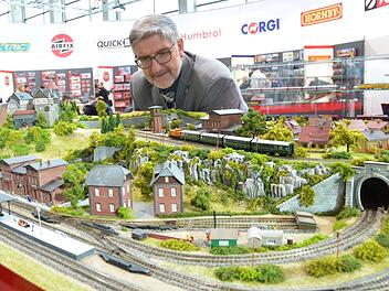 Landrat Michael Busch betrachtet eine Eisenbahnanlage, die die Modellbahnfreunde Rödental für den Stand von Hornby auf der Nürnberger Spielwarenmesse gebaut haben. Foto: Rainer Lutz