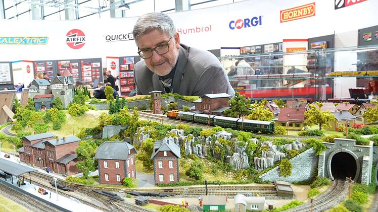 Landrat Michael Busch betrachtet eine Eisenbahnanlage, die die Modellbahnfreunde Rödental für den Stand von Hornby auf der Nürnberger Spielwarenmesse gebaut haben. Foto: Rainer Lutz
