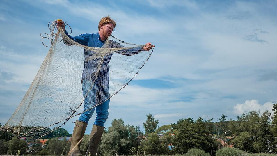 Louis Grimmer wirft sein Netz aus. Die Fischzucht am Alten Kurhaus in Trabelsdorf ist einer von über 100 Direktvermarktern in Stadt und Landkreis Bamberg.  Foto: Lea Schreiber