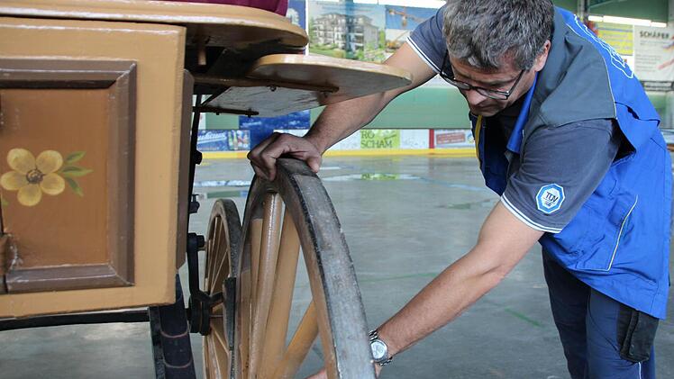 Jürgen Petz vom TÜV Süd prüft die Kutschenräder. Foto: Benedikt Borst