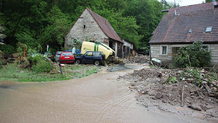 Das Wasser vom Hang schon alles vor sich her: Geröll, Felsbrocken und auch Autos.