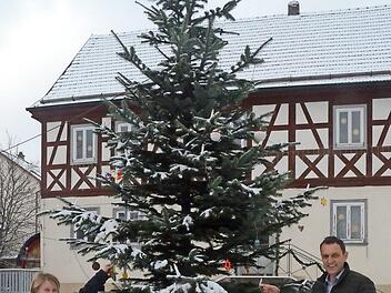 Der dreijährige Luis und sein vierjähriger Bruder Luca schmücken den Christbaum im Weißenbrunner Paradies mit selbstgebastelten Weihnachtsglöckchen. Mutter Franziska Wich und Bürgermeister Jörg Neubauer halfen ihnen. Neubauer steuerte noch eine ganz besondere Weihnachtskugel mit dem Gemeindewappen darauf bei.  Foto: Karl-Heinz Hofmann