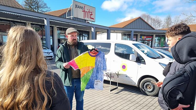 Felix Papsch vom Naturerlebniszentrum Rh&ouml;n zeigt, wer wieviel an einem T-Shirt verdient.