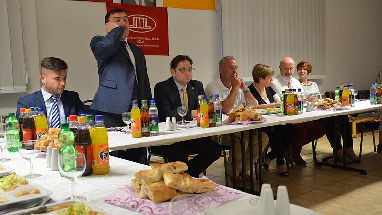 Der Vorbeter, Iman Niyazi Cabbar (Zweiter von links), spricht eine Sure aus dem Koran und den Gebetsruf, ehe um 21.37 Uhr das Fasten gebrochen und gegessen und getrunken werden darf. Foto: Sandra Hackenberg