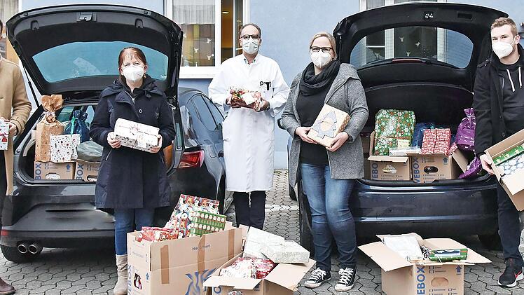 Zwei Autos voll mit Weihnachtspäckchen überbrachten Fabian Fritz (rechts) und Daniel Gambel (links) vom Nachwuchskreis der Siemens AG für die Patienten der Erlanger Kinderklinik. Klinikdirektor Prof. Joachim Wölfle nahm die Geschenke gemeinsam mit Marion Müller (Zweite von links) und Pamela Krebs entgegen.