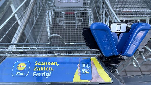 Ein Einkaufswagen mit einem "Scan & Go"-System von Lidl. Es zeigt eine Halterung und Werbung, die schnelles Einkaufen durch Scannen und Bezahlen per App erm&ouml;glicht.