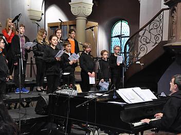Ihr Engagement und Eifer ist faszinierend. Die "Gospel Sparrows" sind die kleinsten Sänger der evangelischen Erlösergemeinde. Rechts: Kirchenmusikdirektor Jörg Wöltche. Fotos: Peter Klopf