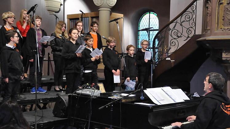 Ihr Engagement und Eifer ist faszinierend. Die "Gospel Sparrows" sind die kleinsten Sänger der evangelischen Erlösergemeinde. Rechts: Kirchenmusikdirektor Jörg Wöltche. Fotos: Peter Klopf