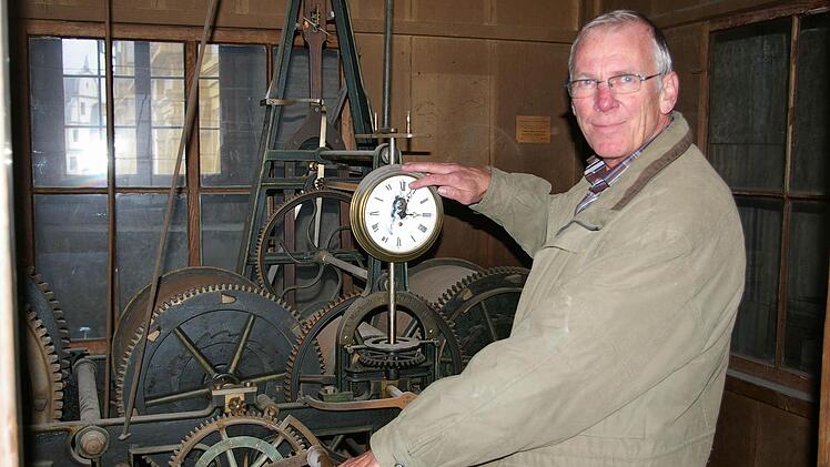 So wär's früher gegangen: Stadtkirchner Karl-Heinz Schilling greift ins Räderwerk der Kirchturm-Uhr. Kirchen-Uhren von heute werden in der Regel ferngesteuert.