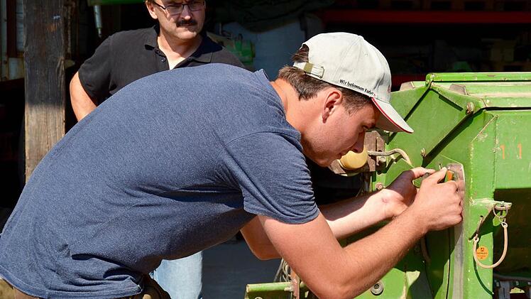 Prüfling Dominik Lieb aus Oberbach an der Sämaschine. Hier stellt er die Schieberstelle ein. Prüfer Stefan Büttner, Landwirt aus Oberwaldbehrungen, schaut zu. Foto: Kathrin Kupka-Hahn