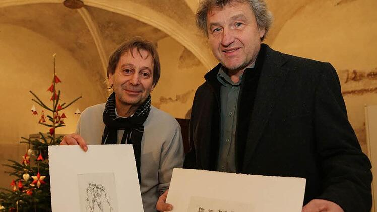 Harald Winter (links) und Walter Dressel zeigen zwei Hans-Dressel-Drucke: "Torero-Mama mit trunkenem Sohn" (links) und "Vier Südtiroler" (rechts). Foto: Barbara Herbst