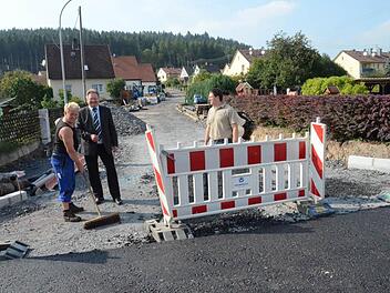 Bürgermeister Hans Pietz (Mitte) und Bauamtsleiter Andreas Schorn freuen sich, dass der erste Bauabschnitt der Sanierung der Ostlandstraße schon eine grobe Asphaltschicht erhalten hat (Vordergrund). Im Hintergrund wird am zweiten Bauabschnitt, beginnend von der Scheffelstraße, gearbeitet. Die Maßnahme soll Ende November abgeschlossen werden.   Foto: Karl-Heinz Hofmann