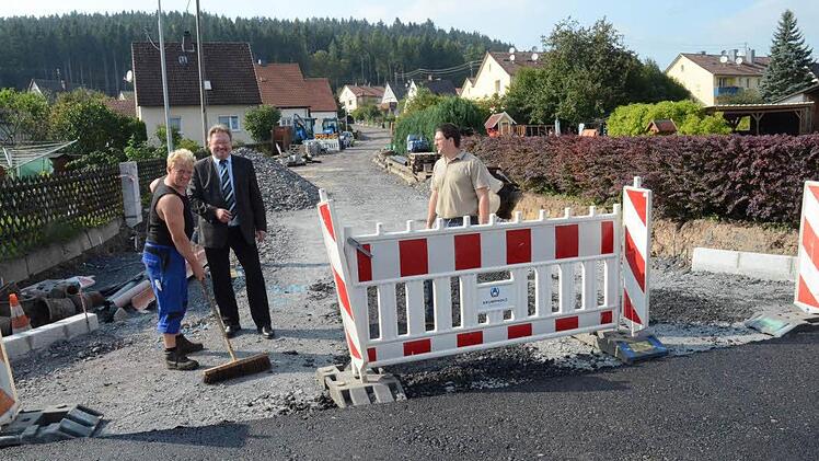 Bürgermeister Hans Pietz (Mitte) und Bauamtsleiter Andreas Schorn freuen sich, dass der erste Bauabschnitt der Sanierung der Ostlandstraße schon eine grobe Asphaltschicht erhalten hat (Vordergrund). Im Hintergrund wird am zweiten Bauabschnitt, beginnend von der Scheffelstraße, gearbeitet. Die Maßnahme soll Ende November abgeschlossen werden.   Foto: Karl-Heinz Hofmann