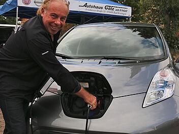 Händler Günter Götz macht es vor: So werden die Elektroautos aufgeladen. Fotos: Gerd Schaar