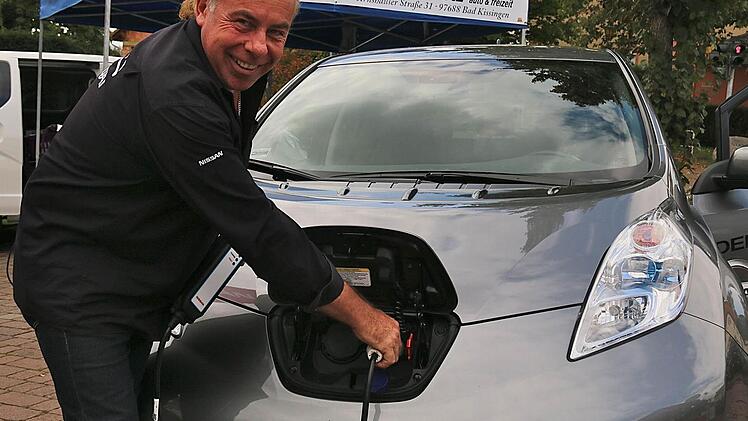 Händler Günter Götz macht es vor: So werden die Elektroautos aufgeladen. Fotos: Gerd Schaar