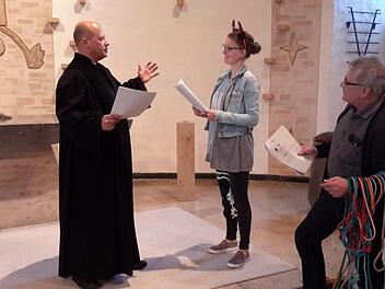 Martin Hentschel (links) und Nicole Fläschner spielen die Hauptrollen bei Luthers Zeitreise. Als Autor und Regisseur fungiert Pfarrer Gerd Kirchner (r.), der auch immer gleich die richtigen Requisiten zur Hand hat. Das Bild entstand bei den Proben in der Friedenskirche.  Foto: Rolf Pralle