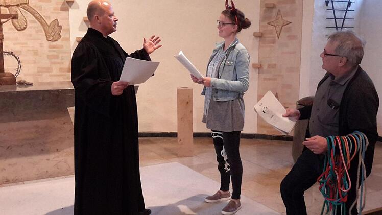 Martin Hentschel (links) und Nicole Fläschner spielen die Hauptrollen bei Luthers Zeitreise. Als Autor und Regisseur fungiert Pfarrer Gerd Kirchner (r.), der auch immer gleich die richtigen Requisiten zur Hand hat. Das Bild entstand bei den Proben in der Friedenskirche.  Foto: Rolf Pralle