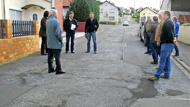 Angesichts der immer wieder aufbrechenden Schäden im Einmündungsbereich der Straße "Zum Lindig" in Kirchaich soll die Fahrbahn im kommenden Frühjahr saniert werden. Das geschieht bereits vor der Dorferneuerung. Unser Bild zeigt den Bauausschuss bei der Besichtigung.  Foto: sw