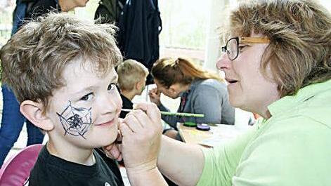 Manuela Sauer vom Kliegl-Kindergarten schminkt Dominik.