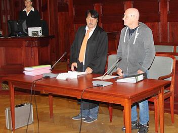 Der wegen schwerer Brandstiftung und versuchten Mords in vier Fällen Anklagte aus Bad Kissingen - links daneben sein Verteidiger, Rechtsanwalt Johannes Driendl aus Bayreuth - erhebt sich beim Eintreten des Gerichts. Foto: Stephan Tiroch