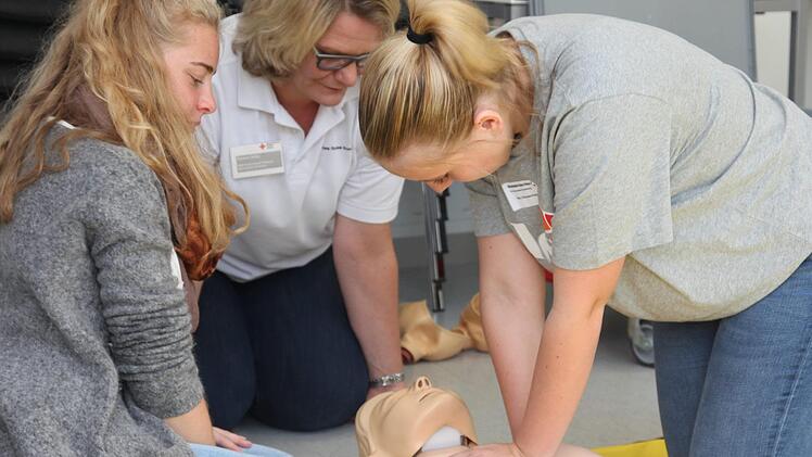 Marie (links) und Mia (rechts) von der Dr.-Ernst-Schmidt-Realschule Ebern &uuml;ben die Reanimation. Simone Gilley, Erste-Hilfe-Ausbilderin beim BRK-Kreisverband, gibt dabei Tipps.Michael Will/BRK