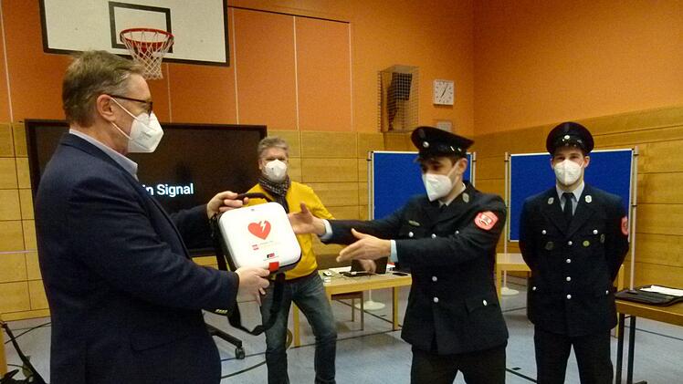 Die Übergabe des Defibrillators während der Gemeinderatssitzung von Bürgermeister Udo Döhler (links) an  (weiter v.l.) den Kommandanten Peter Puff, Julian Knoch und Florian Schwandner.Foto: Lothar Weidner