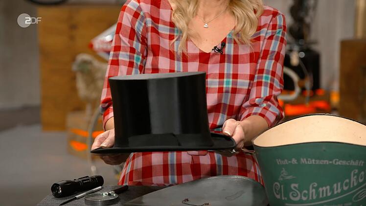 Ein Chapeau Claque samt Hutschachtel aus den 1920er-Jahren sch&auml;tzte Annika Ra&szlig;bach auf 50 bis 80 Euro. Der Wunschpreis f&uuml;r den Klappzylinder lag ebenfalls nur bei 50 Euro. Doch nach einem Duell mit Jos van Katwijk erhielt Julian Schmitz-Avila bei 200 Euro den Zuschlag.