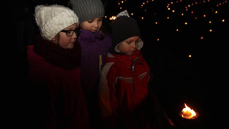 Lena, Moritz und Johanna bewundern andächtig das Feuer.