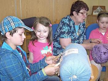 Martina Simon (zweite von rechts) brachte Yannik, Emely und Laura das Klöppeln bei.  Foto: Schülein