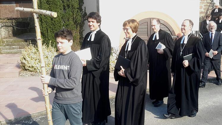 Ein junger Kreuzträger ging nach dem Gottesdienst beim Auszug aus der Kirche voran. Mit einem glücklichen Lächeln auf den Lippen folgten ihm (von links) der neue Pfarrer Niels Hönerlage, Regionalbischöfin Gisela Bornowski, Vakanzvertreter Thomas Kohl und Dekan Till Roth.Foto: Rolf Pralle
