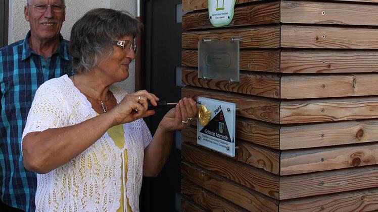 Rita Wittmann durfte selbst mit Hand anlegen, als das Schild für den "Goldenen Ammoniten" angeschraubt wurde. Dahinter ihr Mann