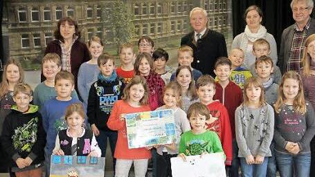 Die beiden Einzelgewinner Emilia Batz und Max Leikeim (jeweils mit ihren Siegerbildern) und die Klasse 3b mit ihrem Klassenpreis gemeinsam mit dem stellvertretenden Landrat Helmut Fischer (Dritter von rechts) und Schulleiter Reinhard Gick-Prandell (rechts) Foto: Gerda Völk