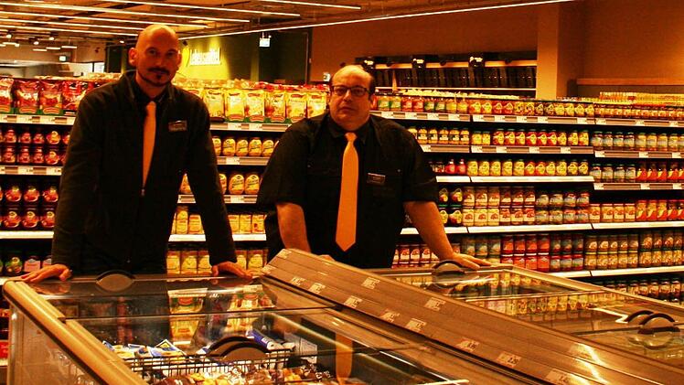 Vor gut gefüllten Regalen freuen sich E-Center-Inhaber Olaf Birger (links) und Marktleiter Harald Streit (rechts) auf den Käuferansturm am Eröffnungstag, Dienstag, 2. Juni.